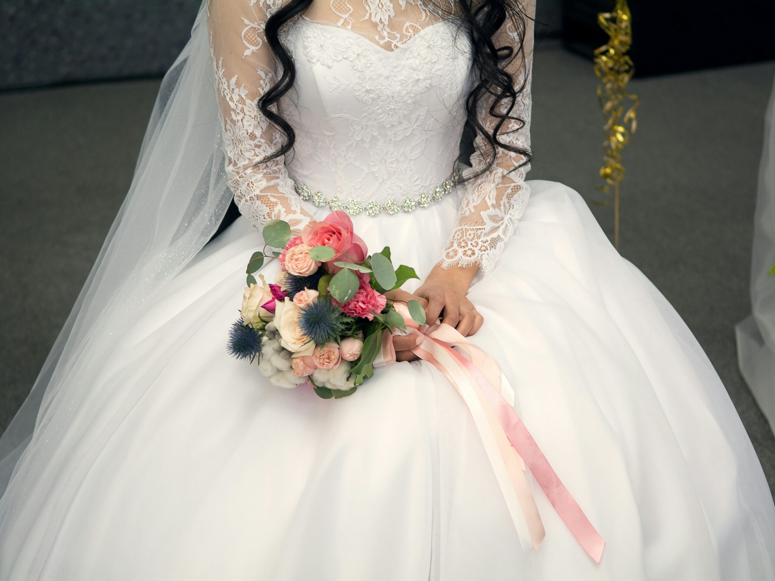 Bride holding wedding dress with travel insurance documents beside