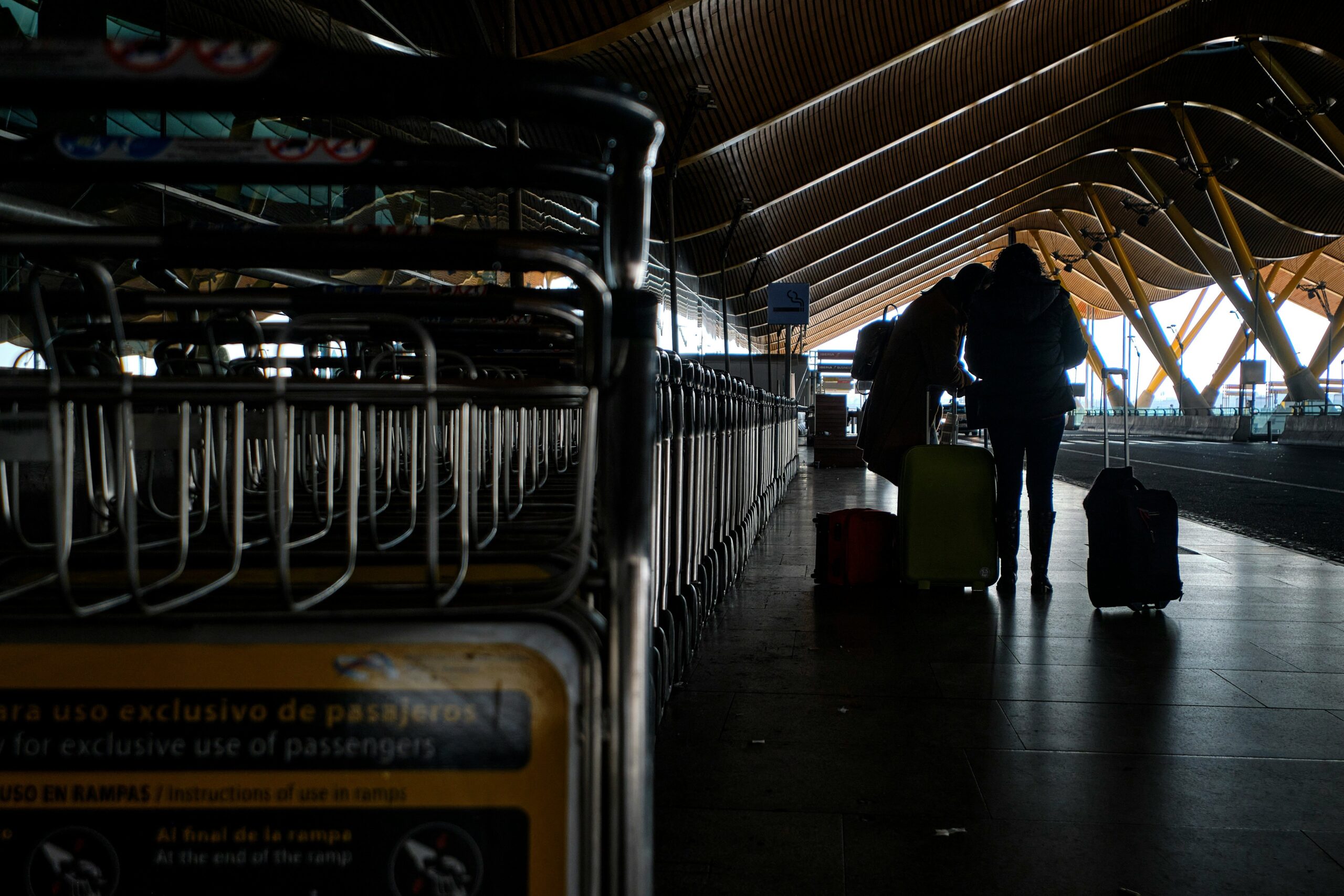 A busy airport baggage carousel with passengers waiting anxiously