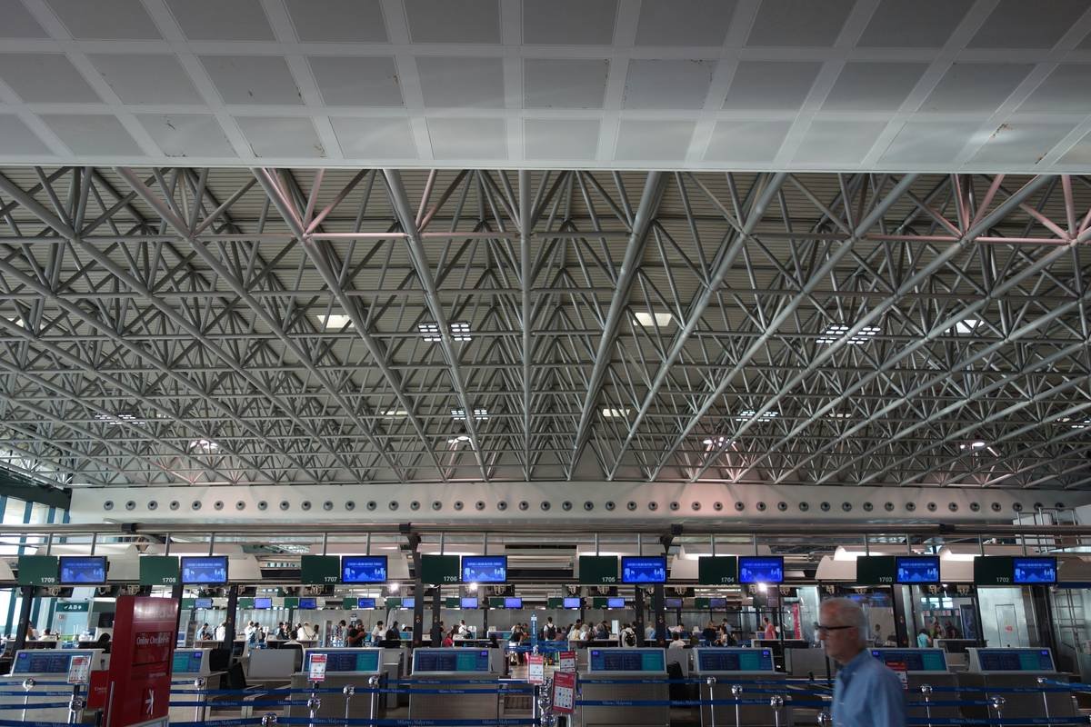 Traveler holding damaged luggage with baggage claim spirit documentation visible